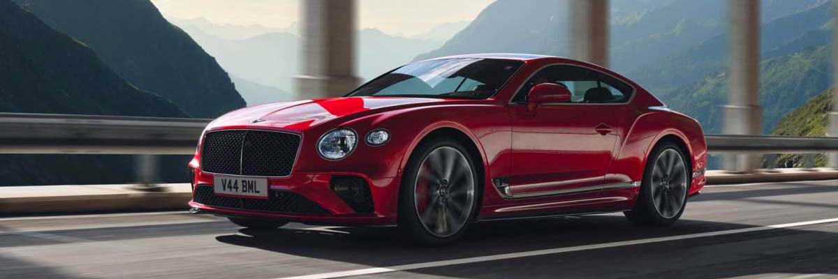 Exterior shot of a Bentley driving on a street.