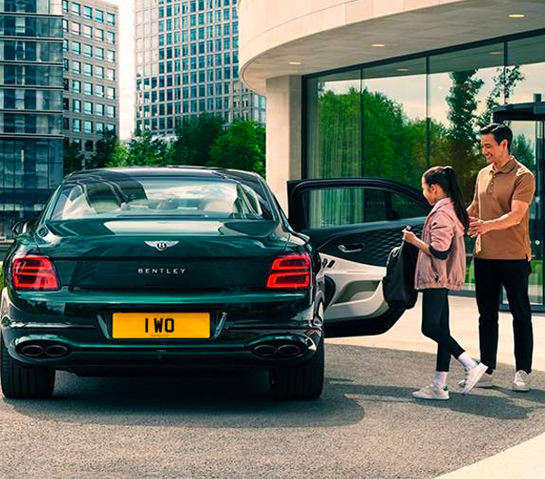 People looking at a new car at a dealership.
