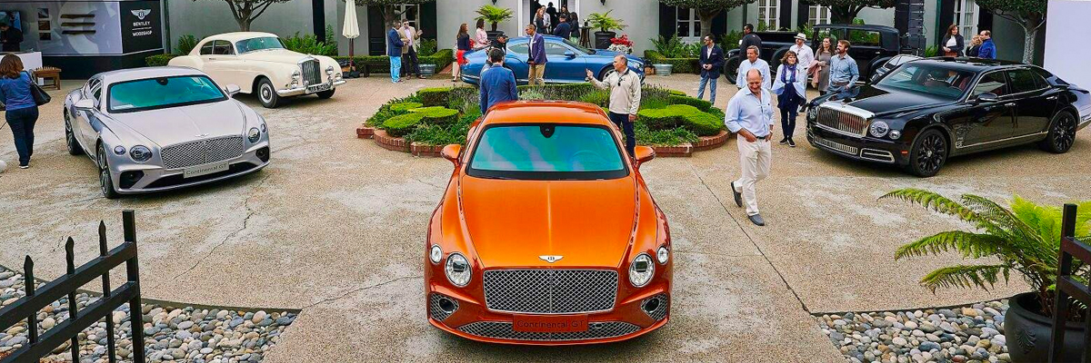 People looking at Bentley vehicles.