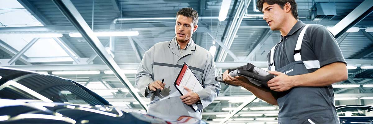 Service image of two service workers working on a BMW vehicle.