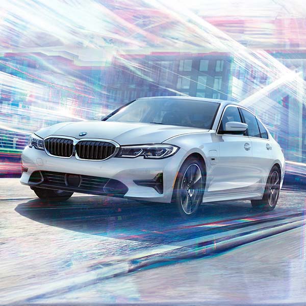 Dynamic head-on driving shot of the 2022 BMW 330e