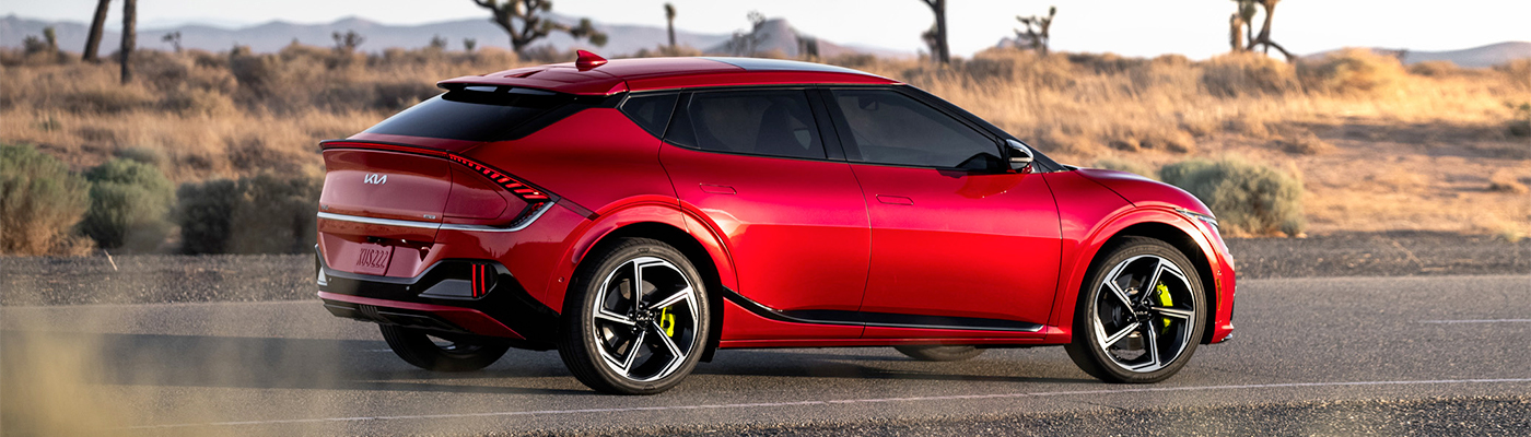 2024 Kia In Runway Red Parked On A Desert Road Side-View 
