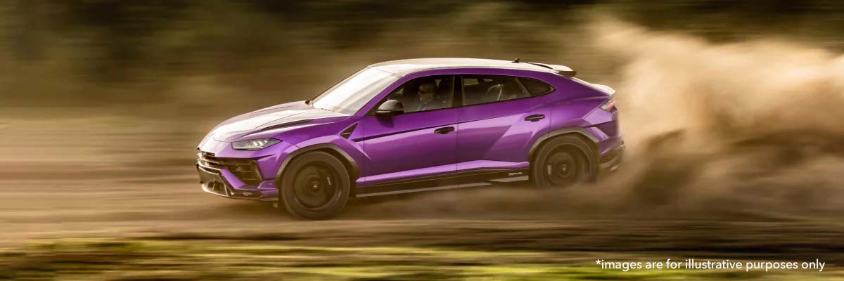lamborghini urus driving on a dirt road.