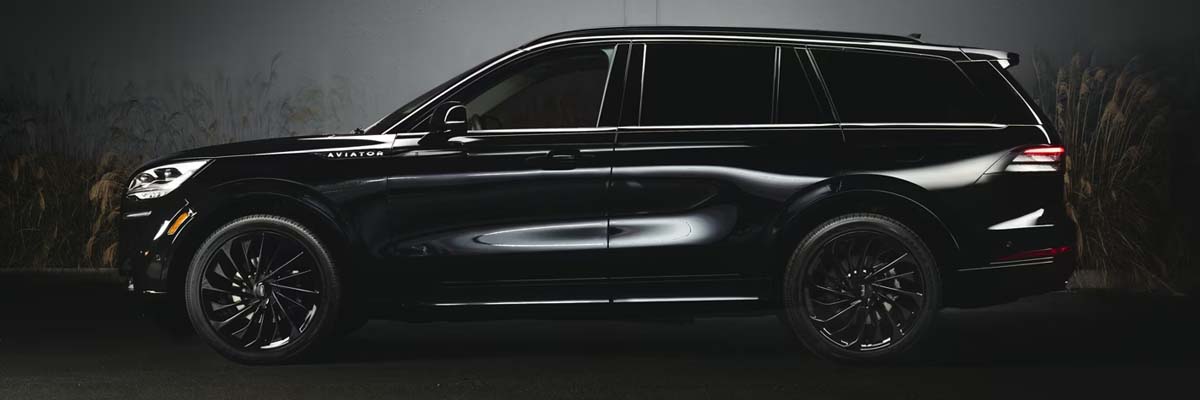 Side shot of a 2024 Lincoln Aviator parked in front of a building at night.